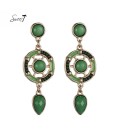 Groene oorhangers met steentjes en een goudkleurige rand