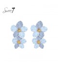 Oorbellen met dubbele lichtblauwe bloemen en goudkleurig hart