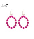 Oorbellen met fuchsia roze kralencirkel en goudkleurige details