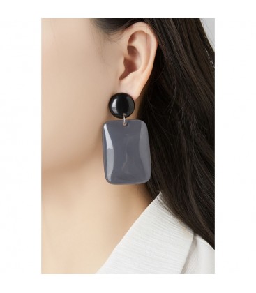 Oorclips geel met ronde en rechthoekige vormen.