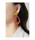 Oorclips oranje ovale hanger met een ronde gele oorknop.