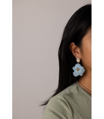 Oorbellen met blauwe bloemen en goudkleurige accenten.