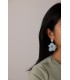 Oorbellen met blauwe bloemen en goudkleurige accenten.